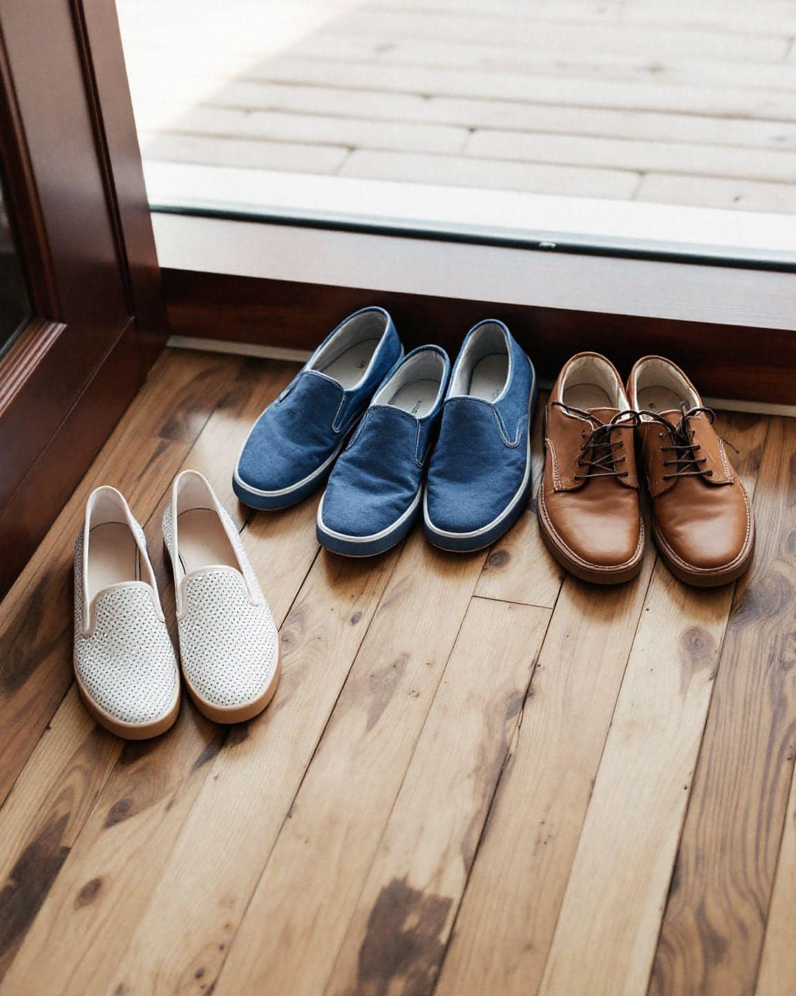 Pairs of shoes lined up by a front door.